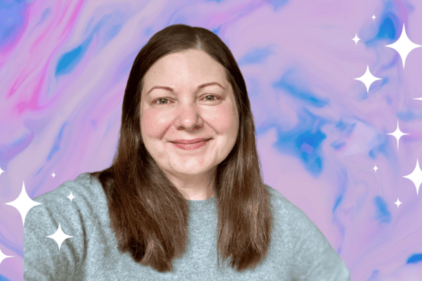 Picture of Tera Lynn Childs smiling and wearing a gray sweater against a swirling marble blue, pink, and purple background.